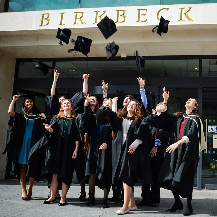 Grads throwing their hats infront of the birkbeck sign